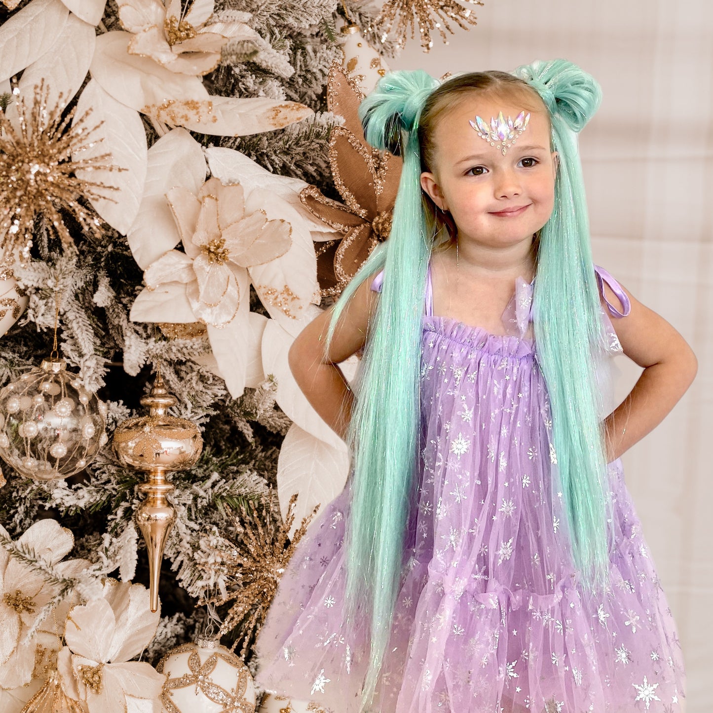 Young girl with long turquoise mermaid pigtails in front of christmas tree for mermaid hair extensions australia